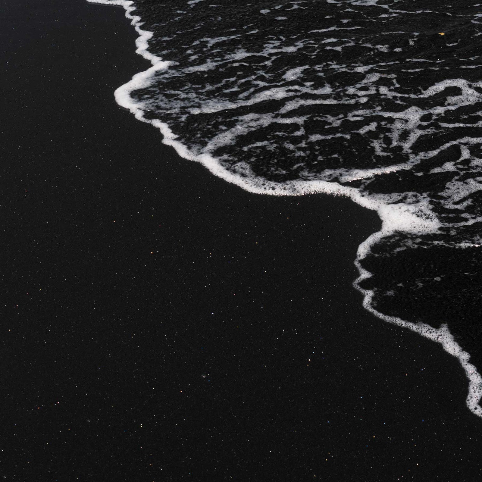 black volcanic sand beach with white sea foam; https://cdn.shopify.com/videos/c/o/v/e6917eb9e29e45f9ba5629fbfe25dd8d.mp4